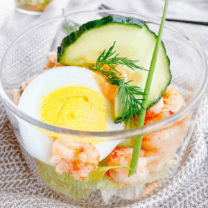 Koolhydraatarme salade met rivierkreeftjes, ei en verse groenten in een glas, ideaal voor een gezond en licht keto-dieet