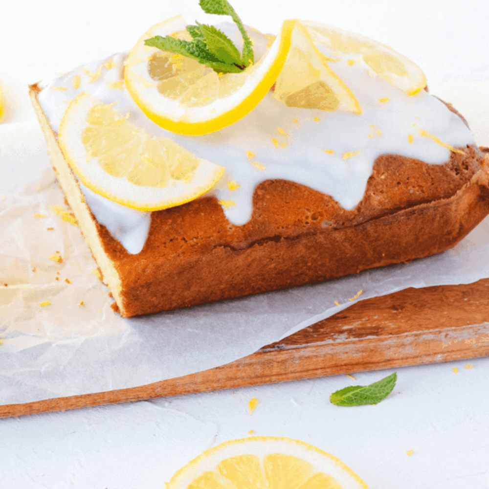 Gezonde citroencake met frisse glazuur en schijfjes citroen op een houten plank