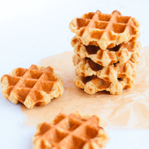 Vanille wafels gestapeld op bakpapier met een goudbruine knapperige structuur op een lichte achtergrond