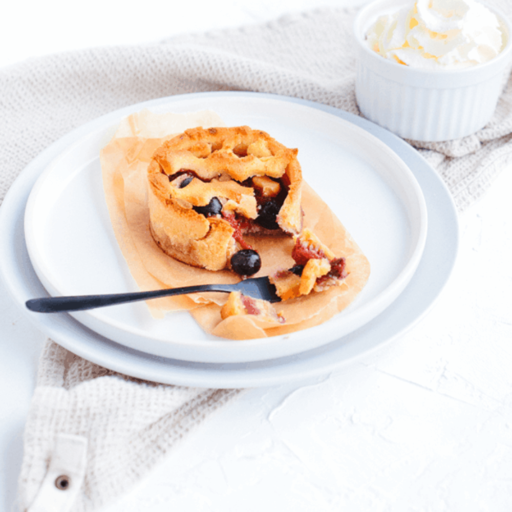 Koolhydraatarme tartelette met rood fruit op een wit bord