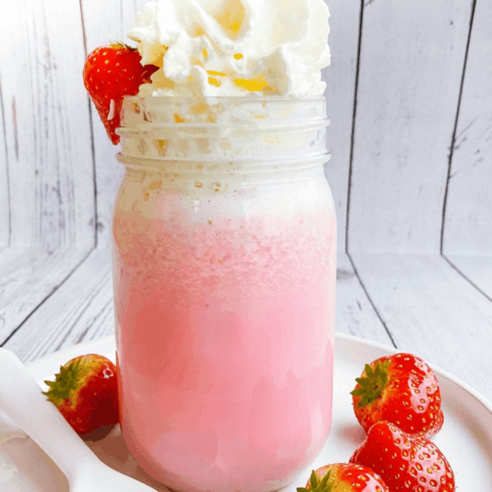 aardbeien milkshake in een glas met slagroom en verse aardbeien