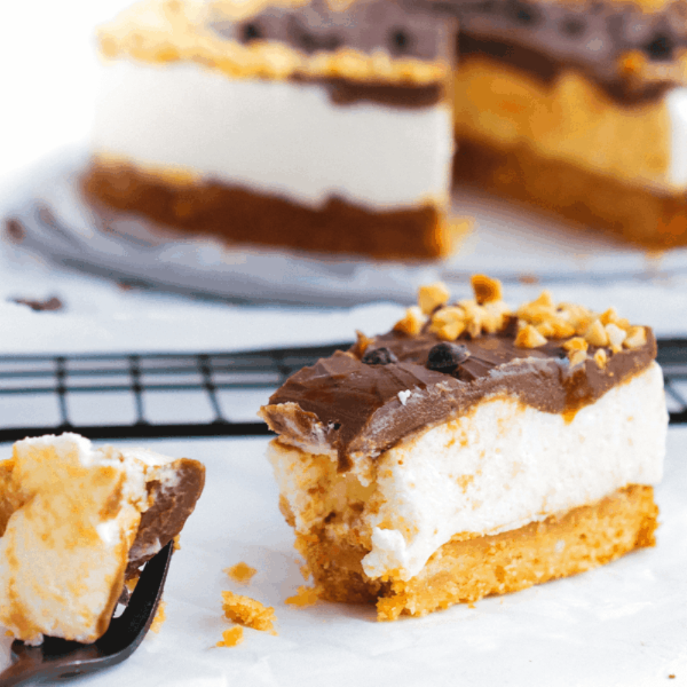 Snickers cheesecake met romige laag chocolade topping en krokante bodem