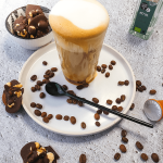 Keto koffie met amandelmelk, schuimige textuur, geserveerd in een glas met romige topping, ideaal voor een koolhydraatarm dieet.