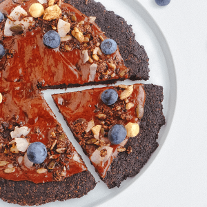 Keto chocolade pizza met romige chocolade, suikervrije granola en verse blauwe bessen als topping.