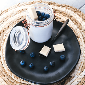 Koolhydraatarme panna cotta met bosbessen en witte keto chocolade, romig en stijlvol geserveerd in een glas.