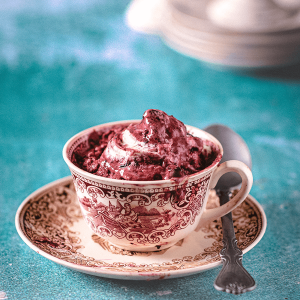 Romige kersen nice cream geserveerd in een kopje met lepel een fris keto dessert gemaakt van diepvries kersen en Griekse yoghurt