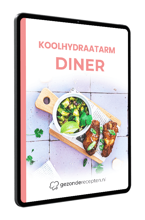 Tablet met de cover van het digitale kookboek “KOOLHYDRAATARM DINER” van gezonderecepten.nl, met een koolhydraatarm diner bestaande uit gegrilde kippenvleugels, een klein kommetje avocadosalsa met limoen, verse kruiden en chilivlokken, geserveerd op een houten snijplank — gezonde koolhydraatarme dinerrecepten.