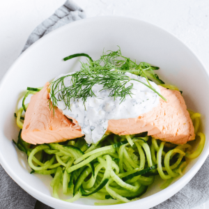 Koolhydraatarme zalm met tzatziki en knapperige komkommer, prachtig opgediend als koolhydraatarme keto maaltijd voor een gezond dieet en gewichtsverlies.