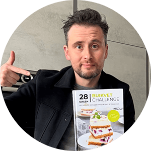 Een man houdt het Nederlandstalige kookboek "28 Dagen Buikvet Challenge" van Gezonderecepten.nl vast — een koolhydraatarm dieetboek voor gewichtsverlies met focus op buikvet.