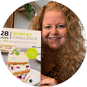 Een persoon houdt het Nederlandstalige kookboek "28 Dagen Buikvet Challenge," een koolhydraatarm dieetboek voor gewichtsverlies met focus op buikvet.