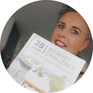 Een persoon houdt het hardcover kookboek "28 Dagen Buikvet Challenge," met heerlijke maaltijden om buikvet te verliezen en zich geweldig te voelen — een tevreden klant van Gezonderecepten.nl.