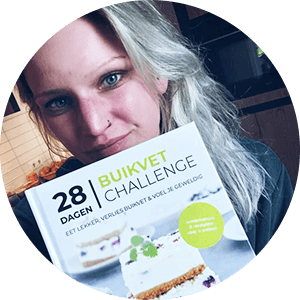 Een persoon houdt het hardcover kookboek "28 Dagen Buikvet Challenge," met een 28-dagen koolhydraatarm dieetplan voor gewichtsverlies en het aanpakken van buikvet — een tevreden klant van Gezonderecepten.nl.