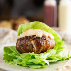 Keto burger met romige big mac saus omwikkeld met bacon en geserveerd op een bedje van verse sla als lowcarb alternatief voor een traditionele burger. Ideaal voor keto en gezond dieet.