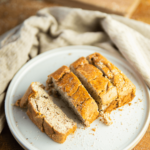 Vier plakjes keto yoghurt cake op een wit bord, met goudbruine korst en vochtige, gevlekte binnenkant, een low-carb dessert geschikt voor keto en gezond dieet.