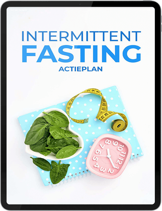 Een tablet met de cover Intermittent Fasting Actieplan, naast een kom spinazie, een gele meetlint en een roze wekker op een blauw notitieboek met stippen — symbool voor een gestructureerde aanpak van intermittent fasting, keto dieet en gezond afvallen