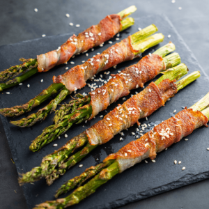 Knapperige asperges omwikkeld met spek en gegarneerd met sesamzaadjes — een smakelijk koolhydraatarm gerecht voor gezond afvallen en diëten