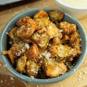 Bowl of healthy air-fried thinly sliced pickle chips, crispy and perfectly seasoned snack