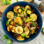 Een keto- en koolhydraatarme maaltijd met krokante spruitjes en courgette, bedekt met gesmolten kaas en stukjes spek — een hartige, gezonde maaltijd voor gewichtsverlies en een gebalanceerd dieet