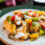Een keto-vriendelijke kip fajita bowl met gebakken kip, kleurrijke paprika’s, rode uien en romige limoensaus — een gezonde koolhydraatarme maaltijd voor gewichtsverlies en een evenwichtig dieet