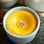 Een klein wit ramekin gevuld met keto crème brûlée, met een glad gebakken custardoppervlak en een licht gekaramelliseerd laagje bovenop — een koolhydraatarm dessert ideaal voor gewichtsverlies en een gezond dieet.