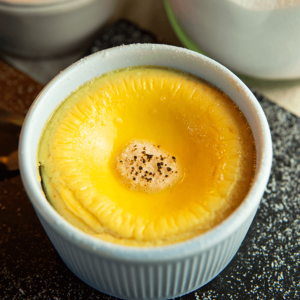 Een klein wit ramekin gevuld met keto crème brûlée, met een glad gebakken custardoppervlak en een licht gekaramelliseerd laagje bovenop — een koolhydraatarm dessert ideaal voor gewichtsverlies en een gezond dieet.