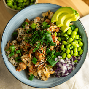 Een kleurrijke koolhydraatarme keto poke bowl met pittige tonijn, knapperige rijst, avocado, edamame en rode ui, gegarneerd met sesamzaad en bosui — ideaal voor gewichtsverlies en een gezond dieet.