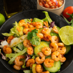 Healthy low-carb shrimp mixed with fresh vegetables, served with salsa and lime on the side
