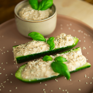 Verse komkommerhelften gevuld met romige tonijnsalade, gegarneerd met basilicumblaadjes, sesamzaad en zwarte peper — een verfrissend koolhydraatarm keto voorgerecht, ideaal voor gewichtsverlies en een gezond dieet.