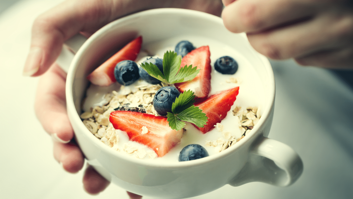 Kom met yoghurt, havermout, aardbeien en blauwe bessen als gezond ontbijt