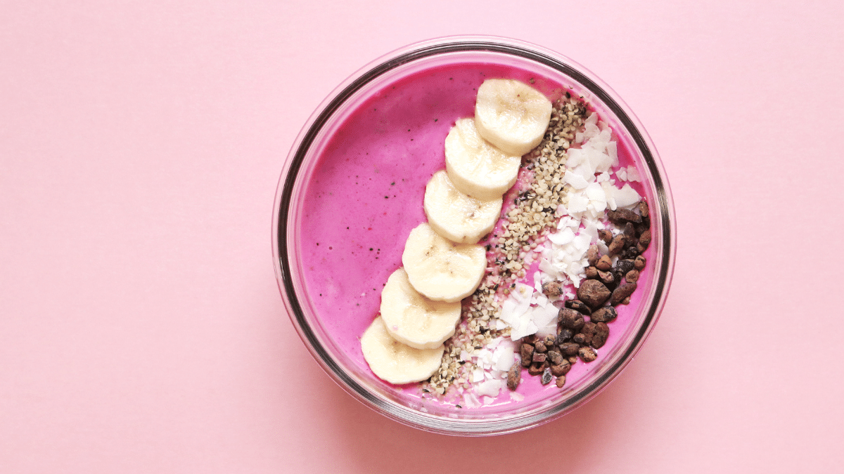 roze smoothie bowl met banaan kokos en cacaonibs