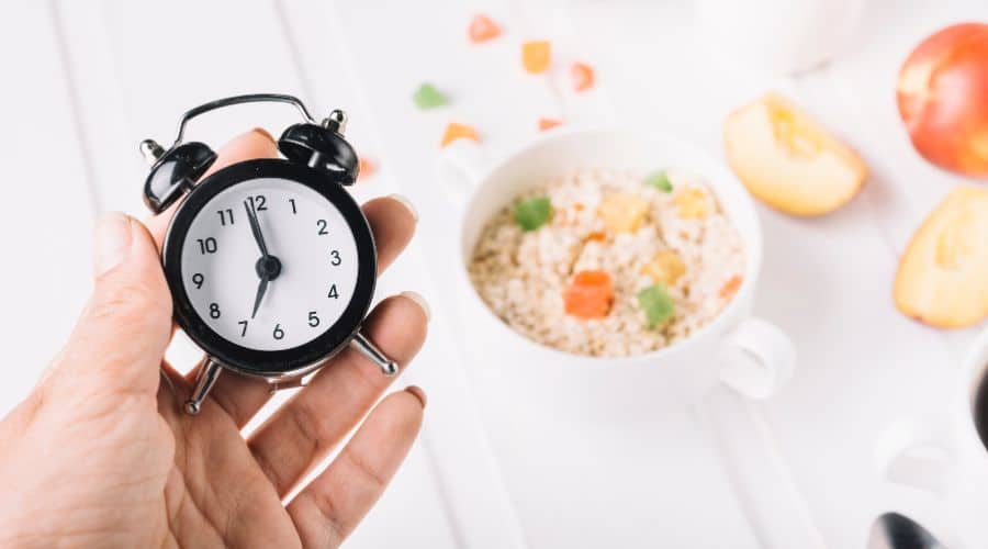 Illustratie van het 16:8 intermittent fasting schema met klok en eetvenster - praktische uitleg van periodiek vasten voor beginners.