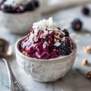 Paleo bessencompote met romige kokosyoghurt, gezond ontbijt uit Nederland met verse blauwe bessen en frambozen, rijk aan antioxidanten en natuurlijke energie.