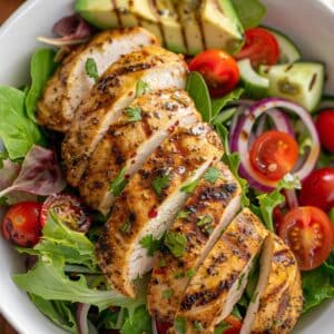 Verse gegrilde kipsalade met romige avocado, limoen en knapperige groenten, gefotografeerd in een gezonde lunchspot in Nederland.