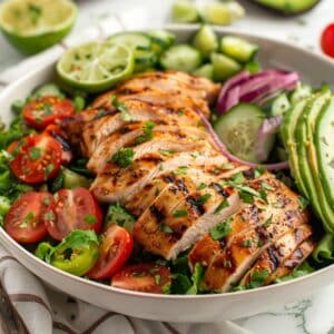 Verse gegrilde kipsalade met avocado, limoen, tomaat en komkommer – gezonde maaltijdsalade uit Nederland, ideaal voor lunch of diner.