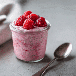 Romige frambozen chia pudding met verse frambozen bovenop als gezonde paleo ontbijtoptie of snack.