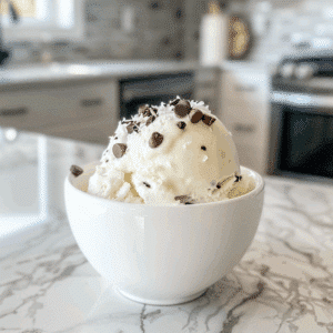 Romig paleo kokos ijs zonder zuivel met chocolade stukjes en kokosrasp als gezonde, natuurlijke ijstraktatie.