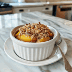 Paleo perzik crumble met sappige perzikpartjes en een goudbruine, knapperige amandel-kokos topping, een gezonde glutenvrije en zuivelvrije zomertraktatie met pure ingrediënten.