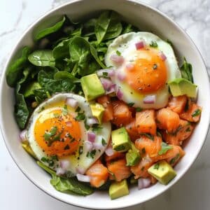 Paleo zalm avocado ontbijtbowl met verse spinazie, eieren en citroen, gezonde koolhydraatarme ontbijtrecepten uit Nederland voor een voedzame en snelle start van de dag.